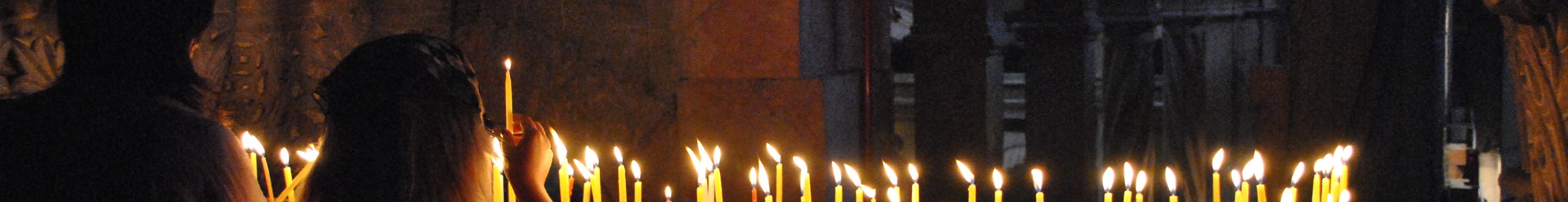 Två personer tänder ljus i uppståndelsekyrkan, Jerusalem.